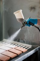 Stříkací pistole, nanášení glazury na keramický střep stříkáním – Marco Ossino / Shutterstock