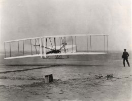 Slavná fotografie prvního letu letounu Wright Flyer, pořízená Johnem T. Danielsem 17. prosince 1903 v 10:35 na pobřeží Kitty Hawk v Severní Karolíně. Vpravo stojí Wilbur Wright – Profimedia.CZ