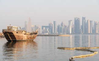 Tradiční dřevěná loď dhau v přístavu na nábřeží Corniche v Dauhá s mrakodrapy čtvrti West Bay v pozadí, 27. září 2025 – Yaman Kumar Photography / Shutterstock