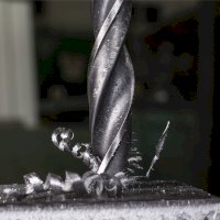 Detail vrtáku, vrtajícího do kovu – David Orcea / Shutterstock