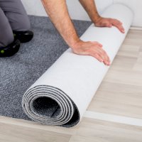 Muž pokládající koberec – Andrey_Popov / Shutterstock