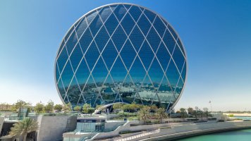 Kruhová výšková budova Aldar Headquarters v Abú Zabí ve Spojených arabských emirátech – Kirill Neiezhmakov / Shutterstock