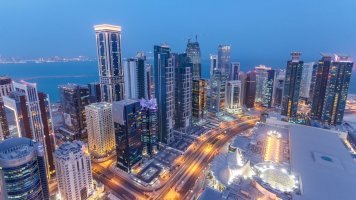 Letecký večerní pohled na mrakodrapy čtvrti West Bay v Dauhá v Kataru – Kirill Neiezhmakov / Shutterstock