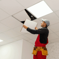 Strop, pracovník, provádějící finální dokončení stropního podhledu – Andrew Angelov / Shutterstock