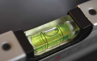 Detail bublinky v libele při ve vodorovné poloze mezi ryskami – maradek / Shutterstock